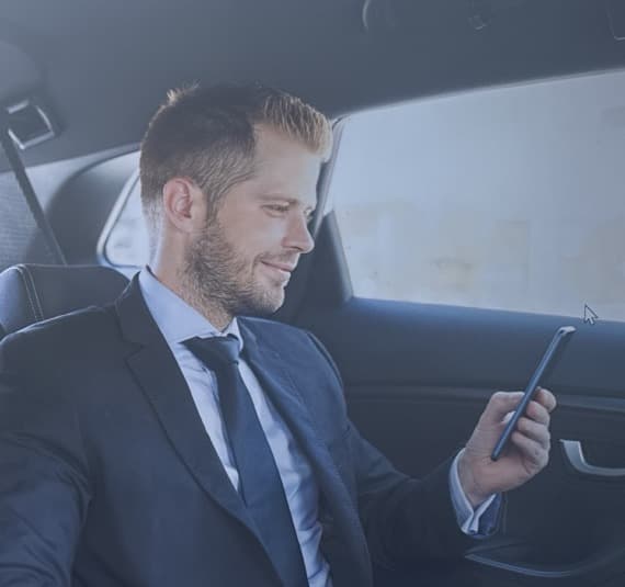 Executive passenger using a smartphone during chauffeured transportation