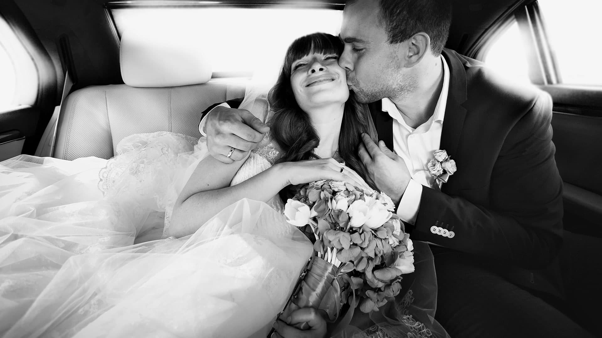 Bride and groom riding in a limousine